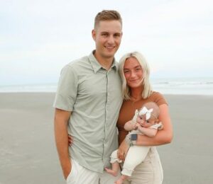 Sam Merrill with his wife and baby